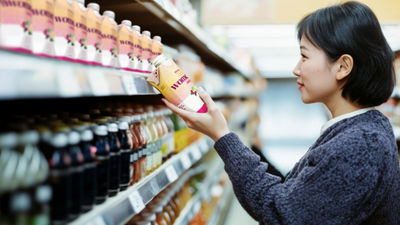 Woman looking at beverages in carton in super market